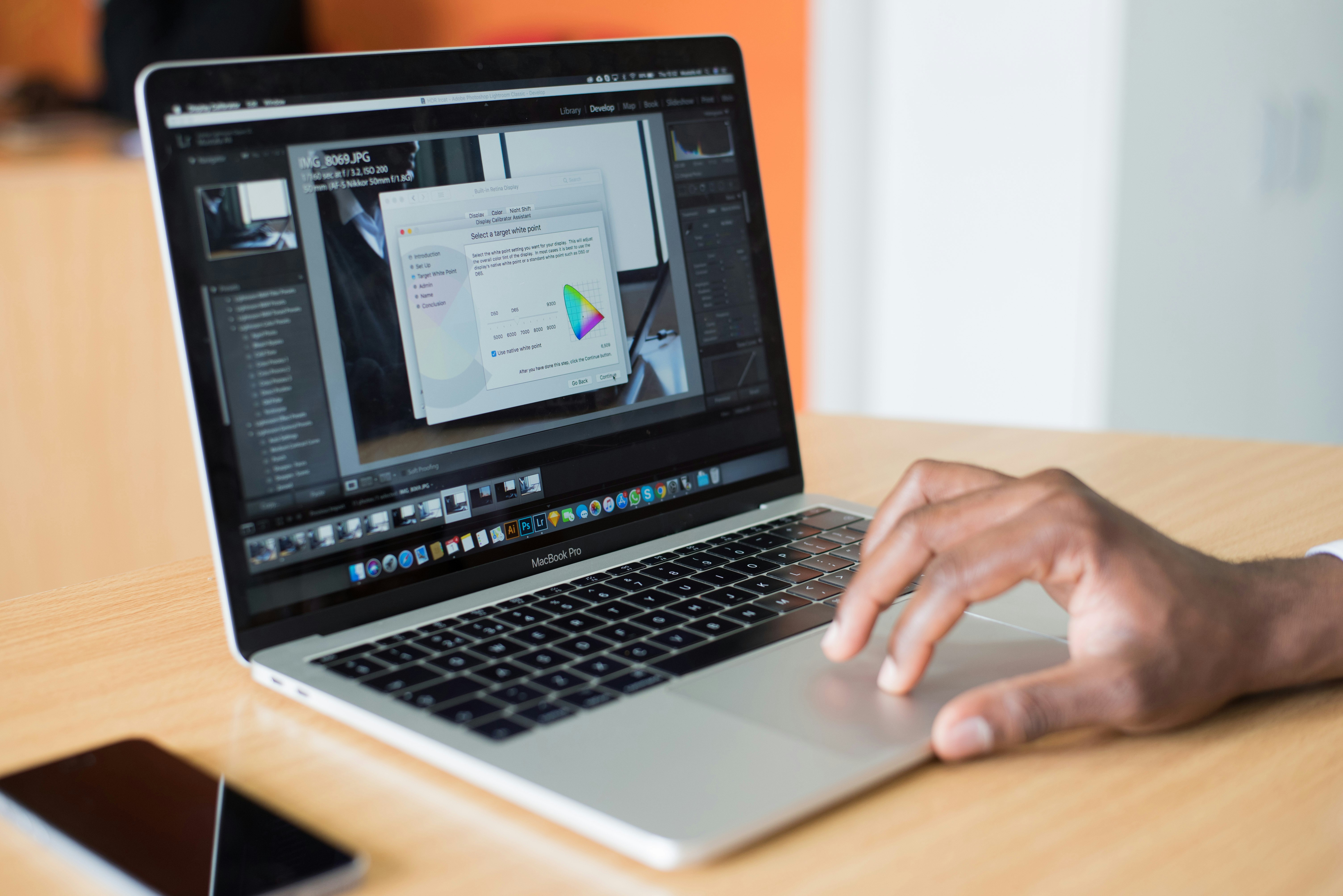 person using MacBook Pro on brown wooden table